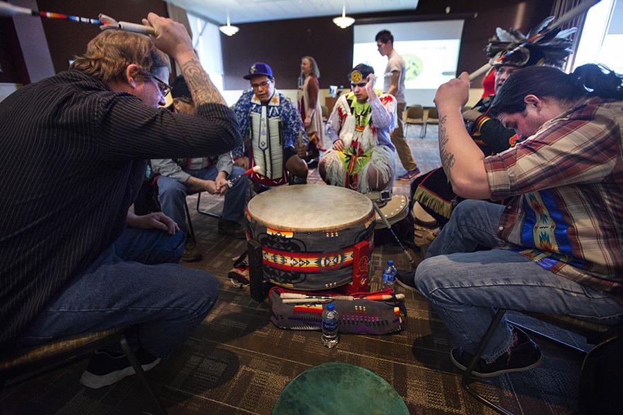 苏必利尔湖赤崖乐队的六名成员表演传统的击鼓.