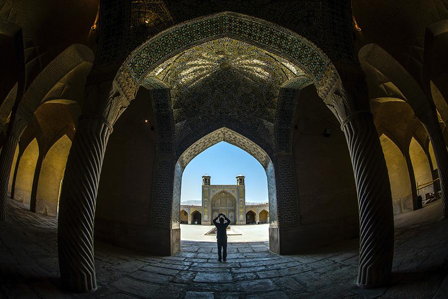 一个人站在伊朗的建筑物之间.