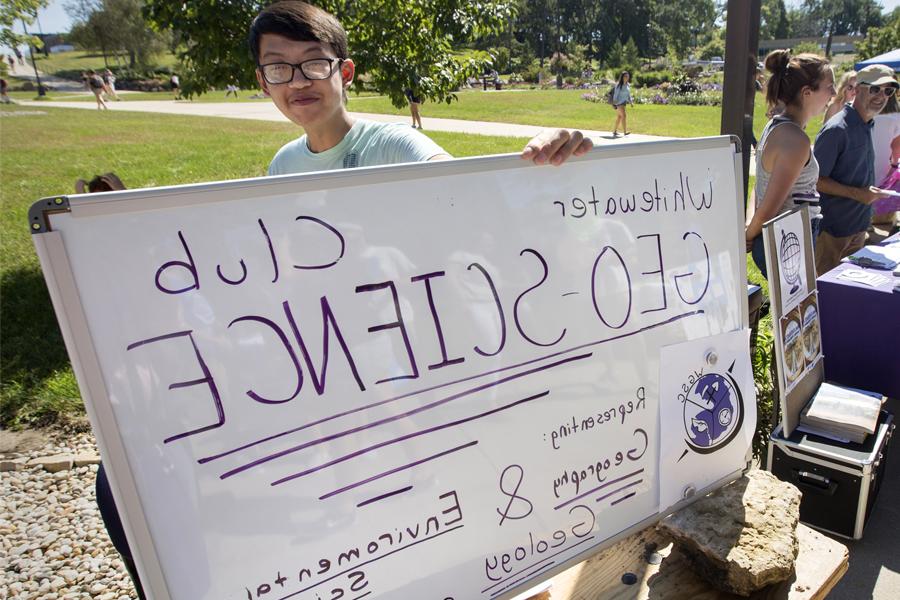 A student holds a sign that says Geo Science Club during the Involvement Fair.