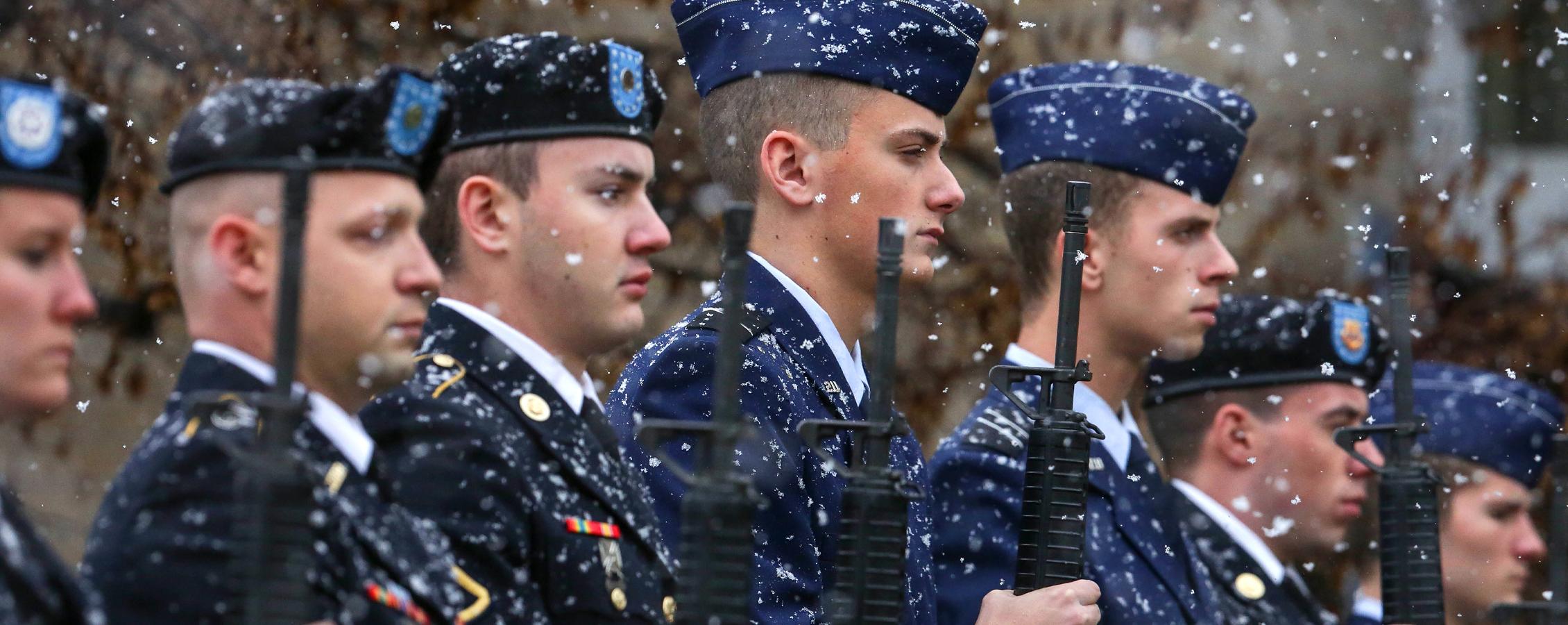 下雪时，老兵们拿着步枪站在那里.