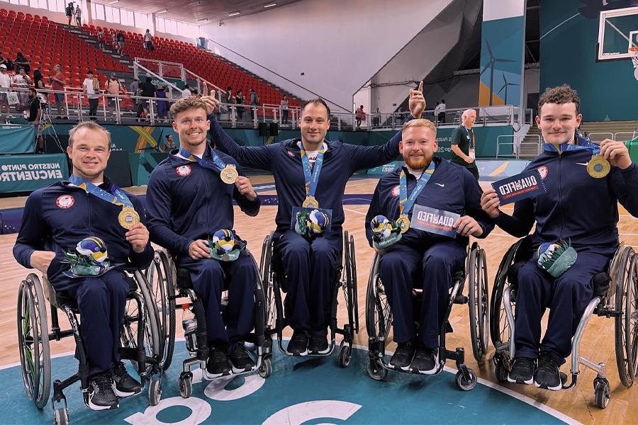 战鹰轮椅篮球运动员与金牌聚集在一起.
